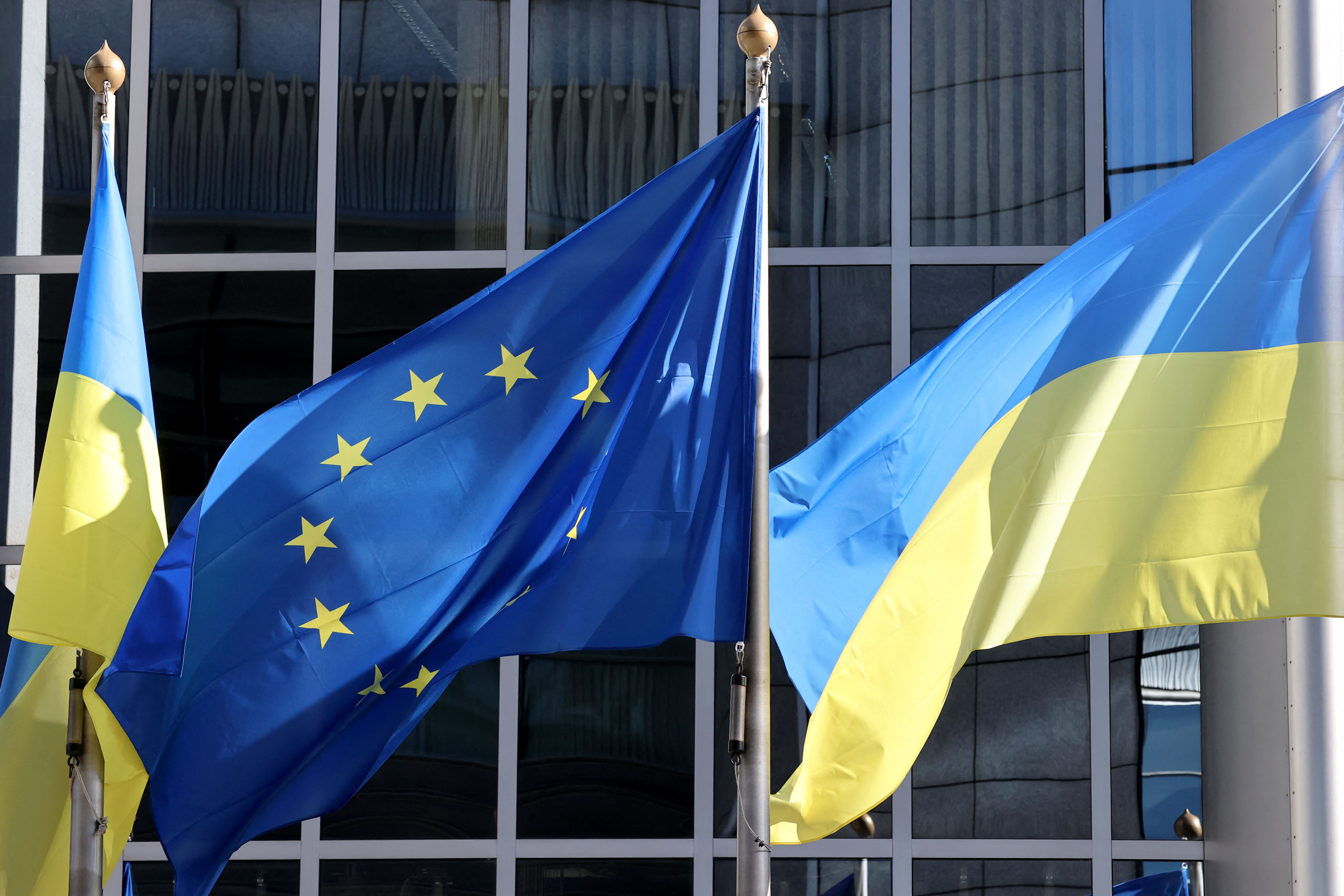 The Ukrainian flag flutters along side the European Union flag outside the European Parliament headquarters to show their support for Ukrania after the nation was invaded on February 24 by Russia, in Brussels on February 28, 2022. (Photo by François WALSCHAERTS / AFP) (Photo by FRANCOIS WALSCHAERTS/AFP via Getty Images)
