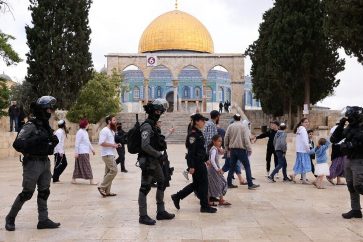 Israeli police accompany a group of Jewish visitors past the Dome of the Rock mosque at the al-Aqsa mosque compound in the Old City of Jerusalem on May 5, 2022. - Tourists and Jewish groups are allowed by Israeli police to enter the Al-Aqsa mosque compound for few a hours per day. The compound is revered as the site of two ancient Jewish temples, and home to al-Aqsa Mosque, Islam's third holiest site. Jews are allowed to enter the mosque compound but not to pray there. (Photo by AHMAD GHARABLI / AFP)