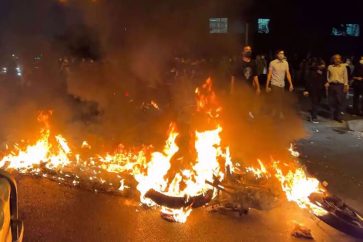 Rioters gather near a motorbike on fire in Tehran on 19 September three days after the death of Mahsa Amini. (File photo by AFP)
