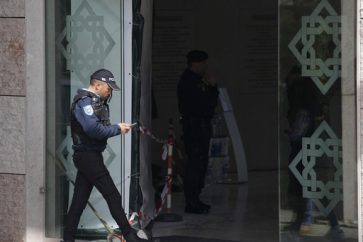 A police officer walks at the entrance of a Muslim center in Lisbon, Portugal, Tuesday, March 28, 2023. (AP Photo/Armando Franca)