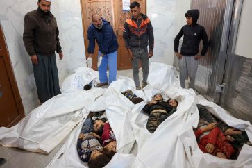 EDITORS NOTE: Graphic content / Relatives stand over the bodies of children killed an Israeli strike that targetted an area in Khan Yunis on the southern Gaza Strip on October 25, 2024, at the European Gaza Hospital amid the ongoing war between Israel and the Palestinian militant group Hamas. (Photo by BASHAR TALEB / AFP)