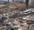 Trucks carrying bodies of 50 martyrs pass through Kfarkila streets filled with debris left by the Israeli war